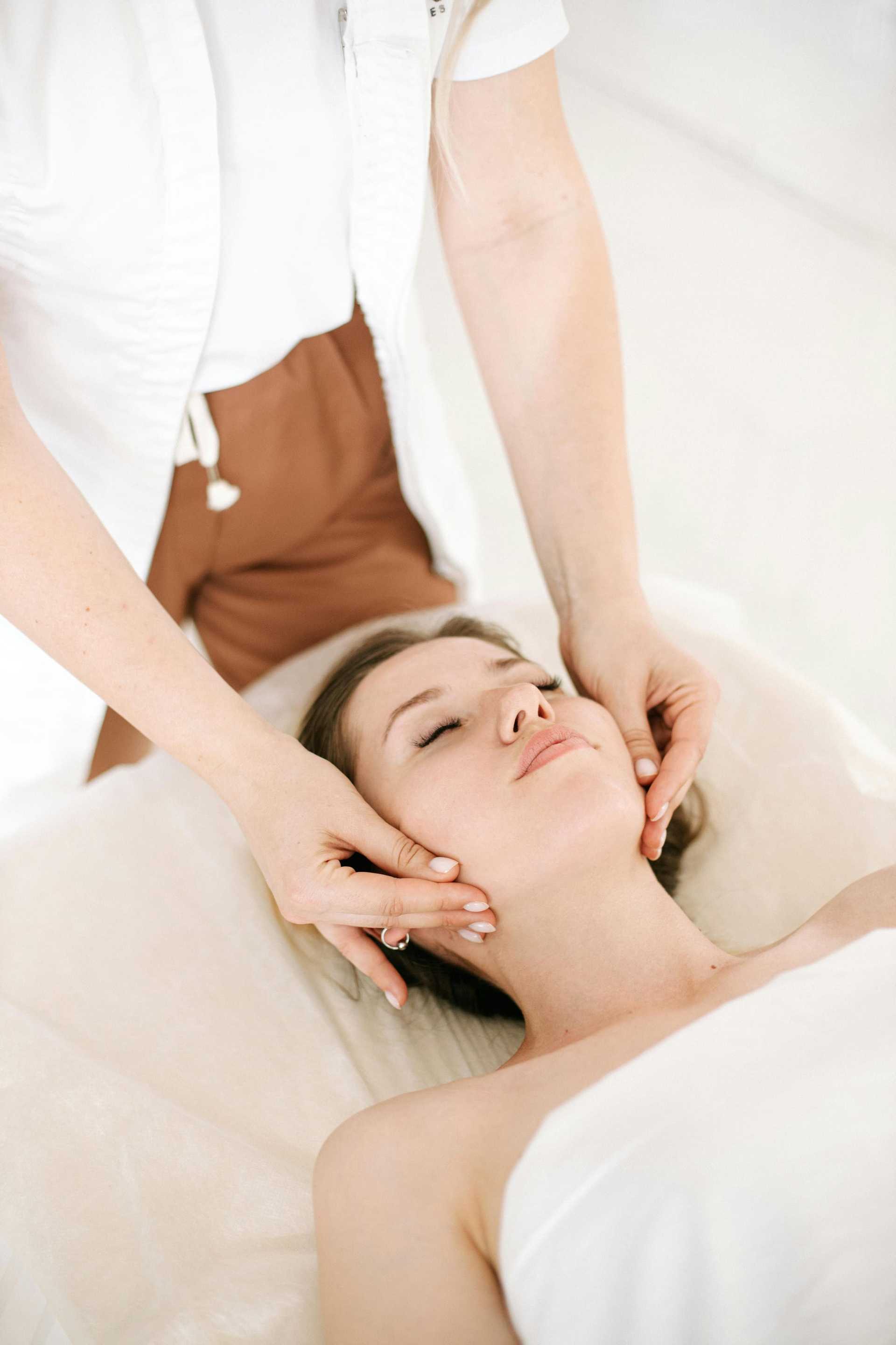 Person receiving a calming facial massage in a spa setting.